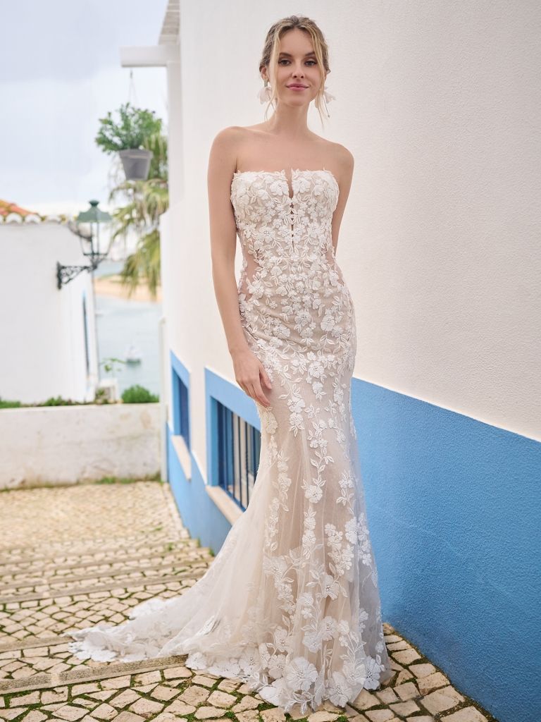 A woman in a wedding dress is standing in front of a building.
