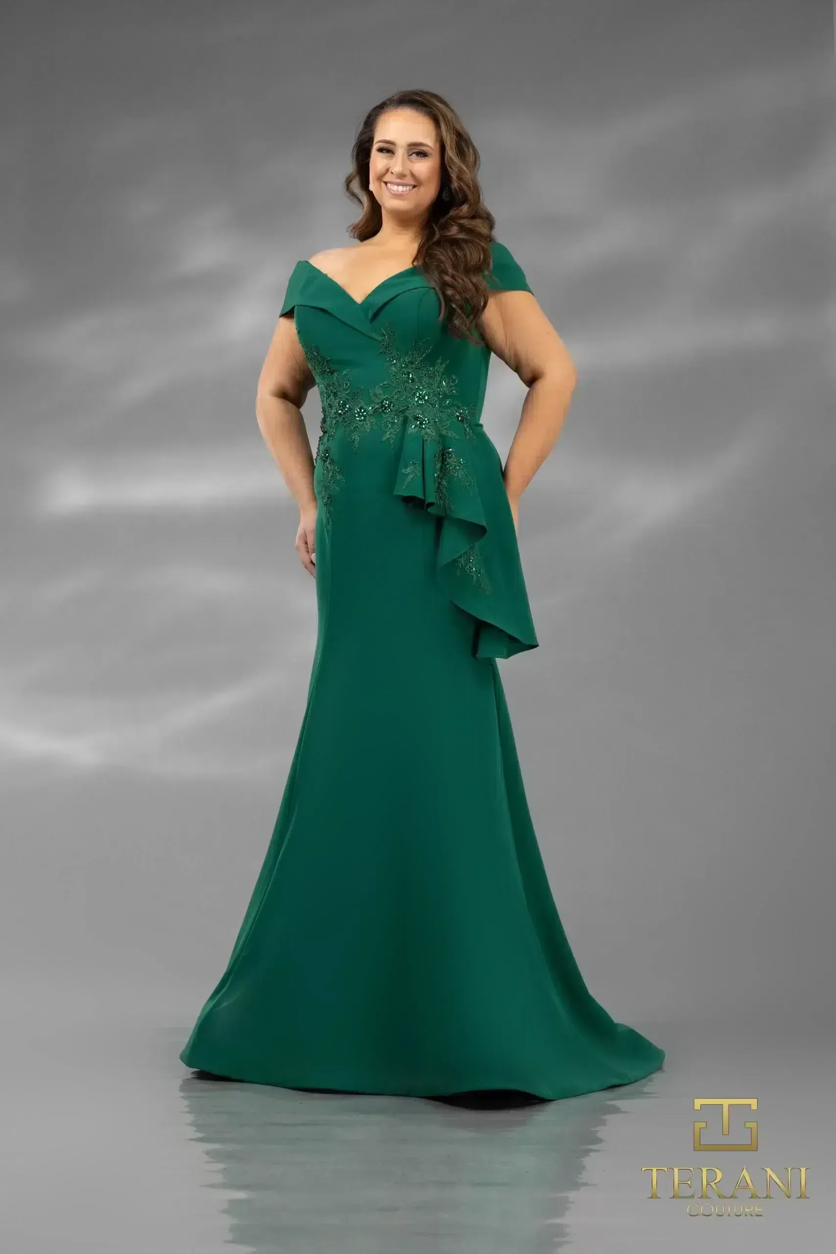 A woman in a green dress is standing on a gray background.