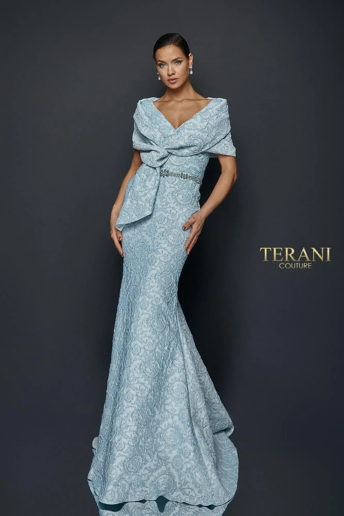 A woman is wearing a light blue lace dress with short sleeves.