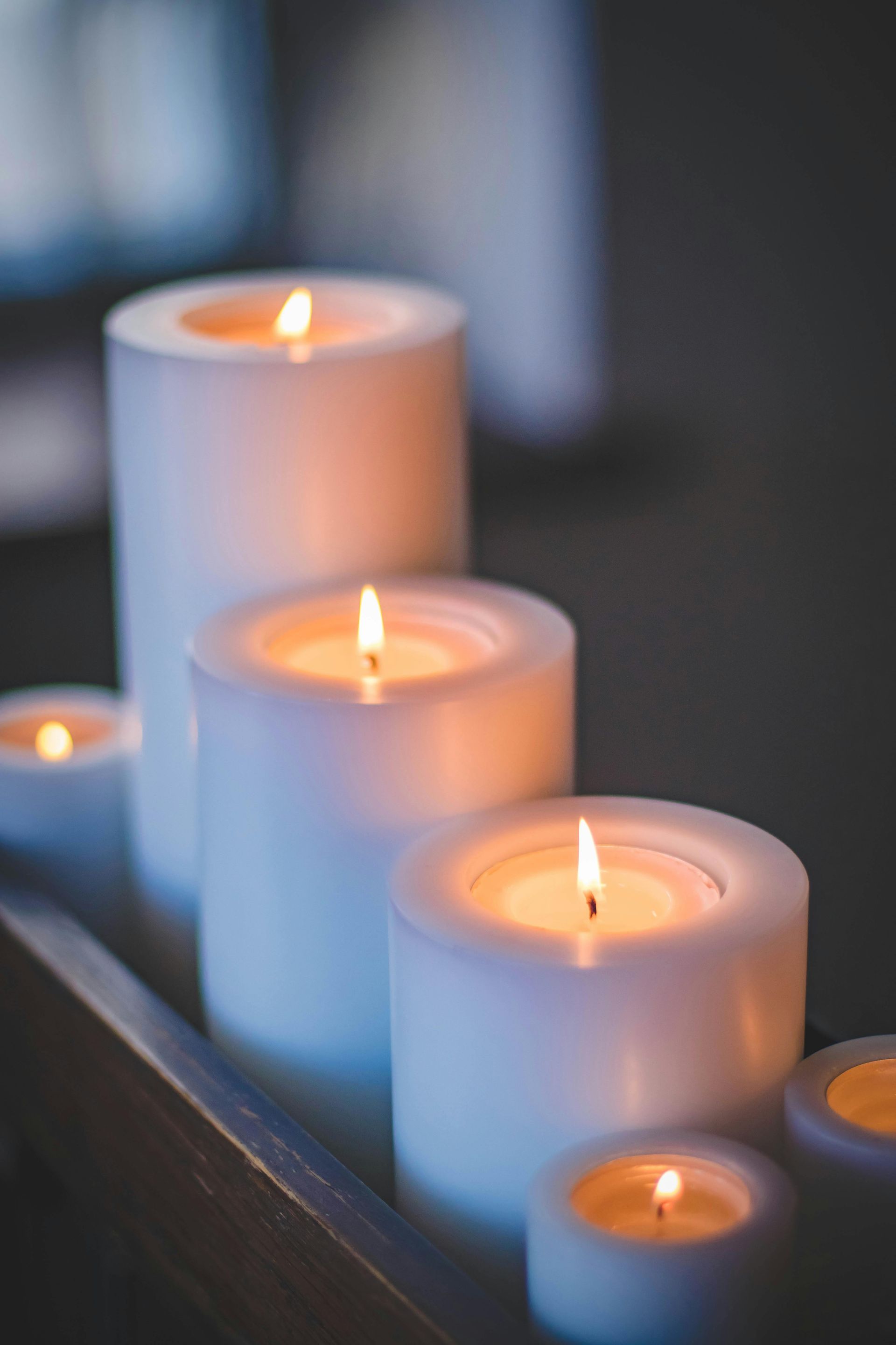 White pillar candles with lit orange flames.