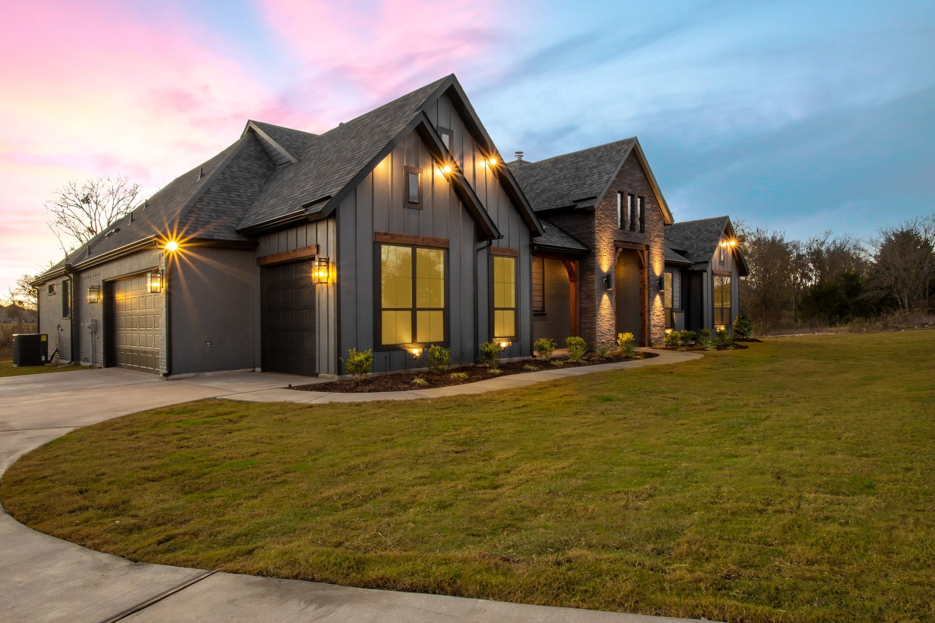 Modern home with exterior landscape lighting around the house.