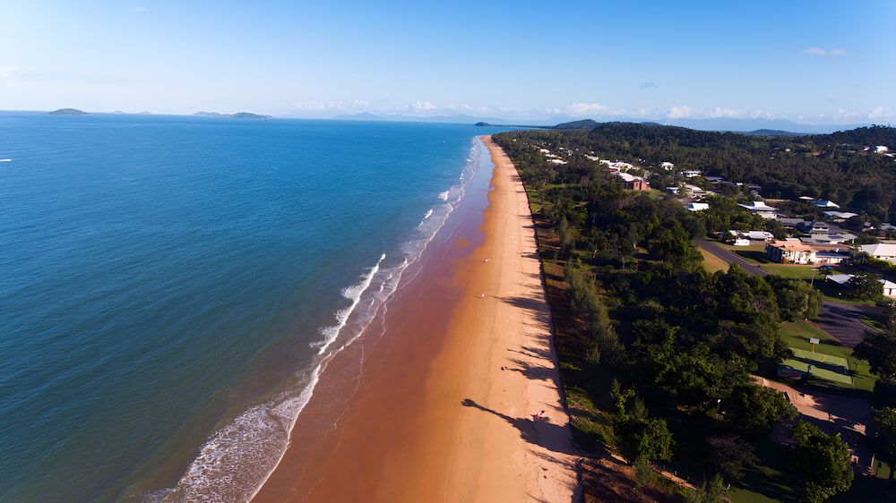 Beach Long, Sandy Shore, Blue Ocean, and Houses Nestled in Trees — Greenaway Green Waste Removal in Mission Beach, QLD