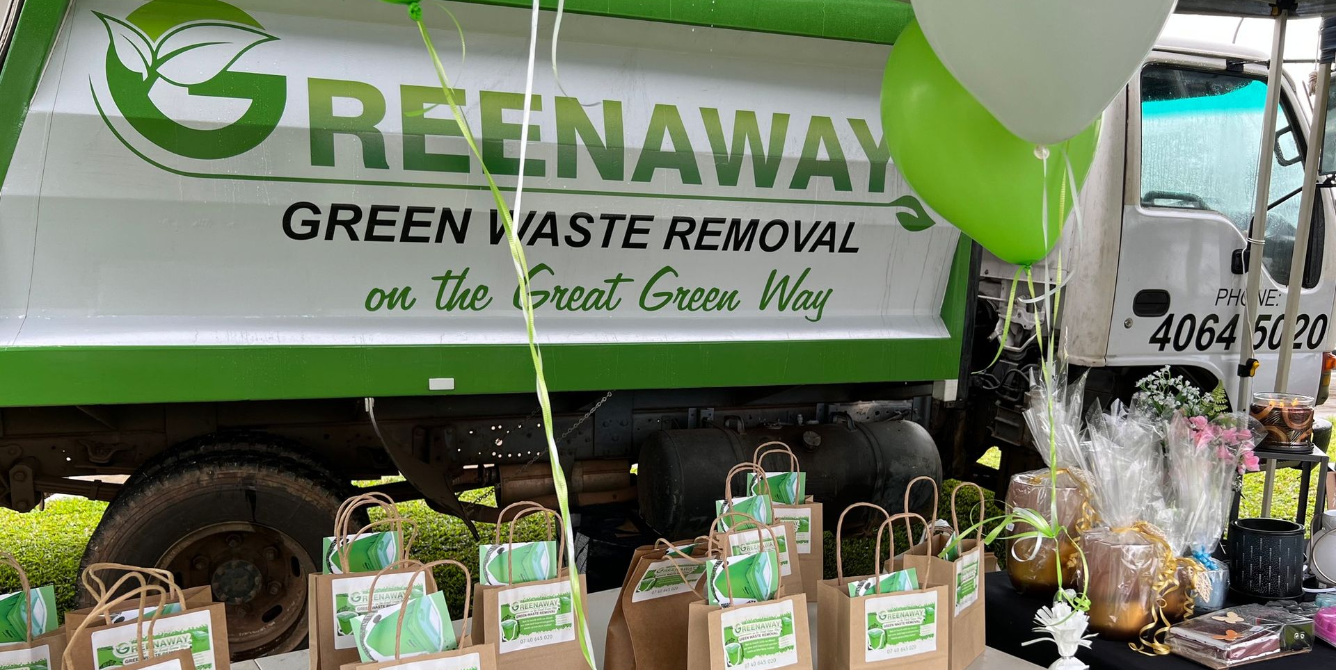 A Greenaway truck with gifts and balloons. Green and white colors, 