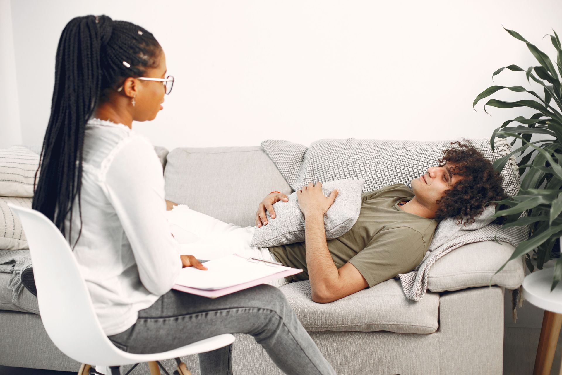 Therapist meeting with a client on a sofa in a bright living room