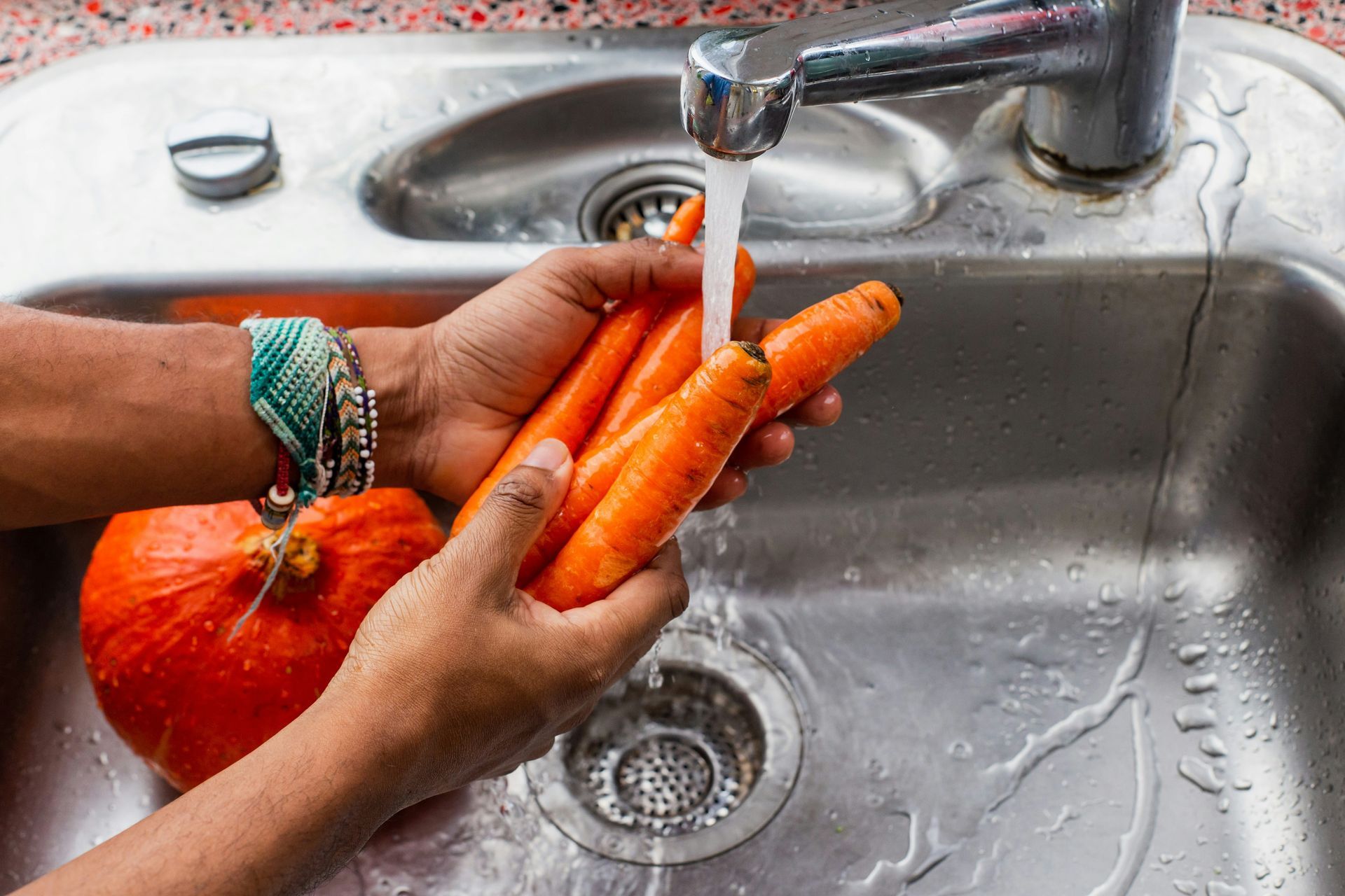 Two women are sitting on the floor in a bathroom next to a bathtub.