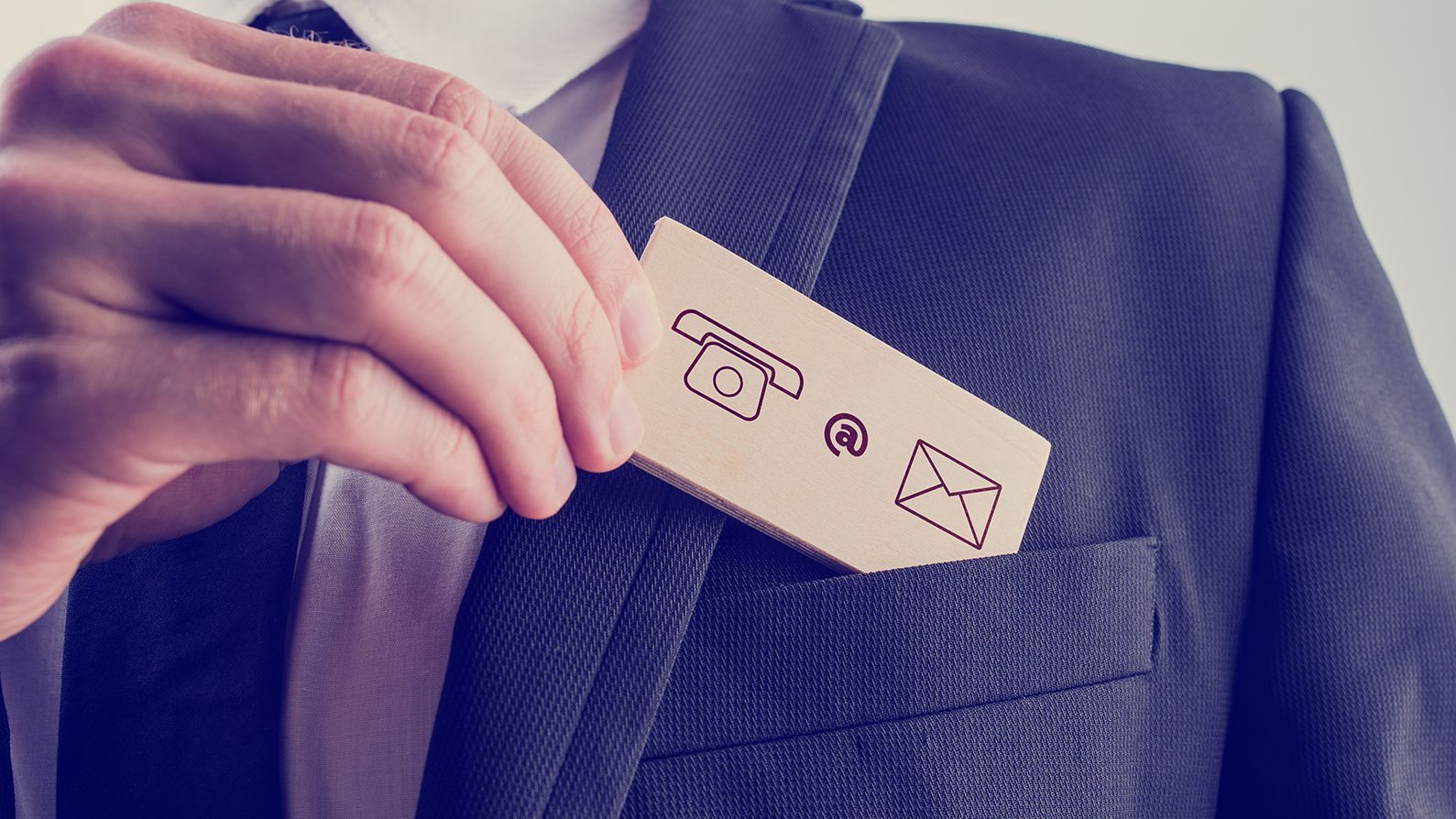 businessman removing wooden card contact icons