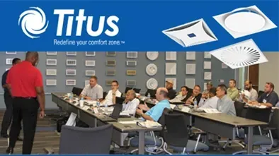 Titus training room with people seated at tables watching a presenter in a red shirt.