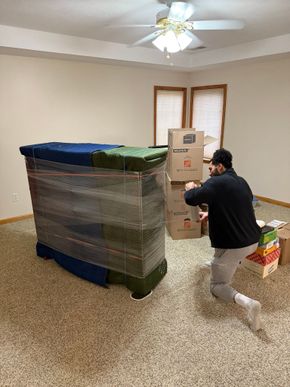 “Professional movers wrapping furniture with moving blankets