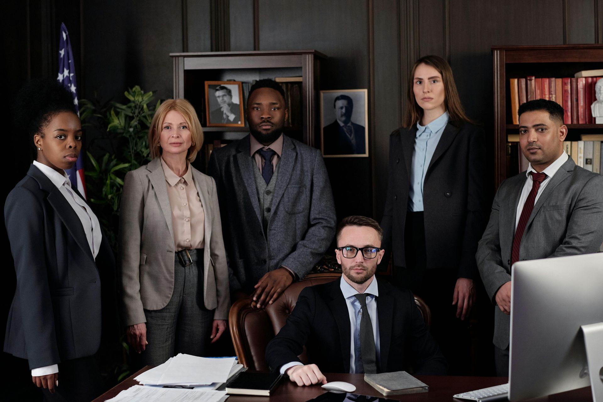 A group of lawyers are posing for a picture in an office.
