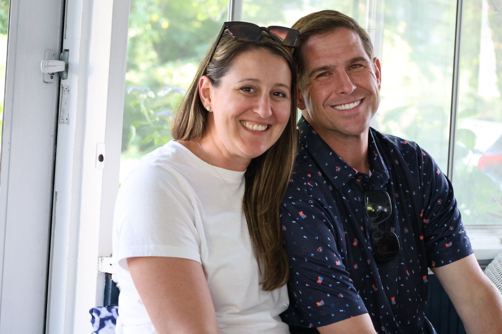 Smiling couple sitting together indoors near a bright window