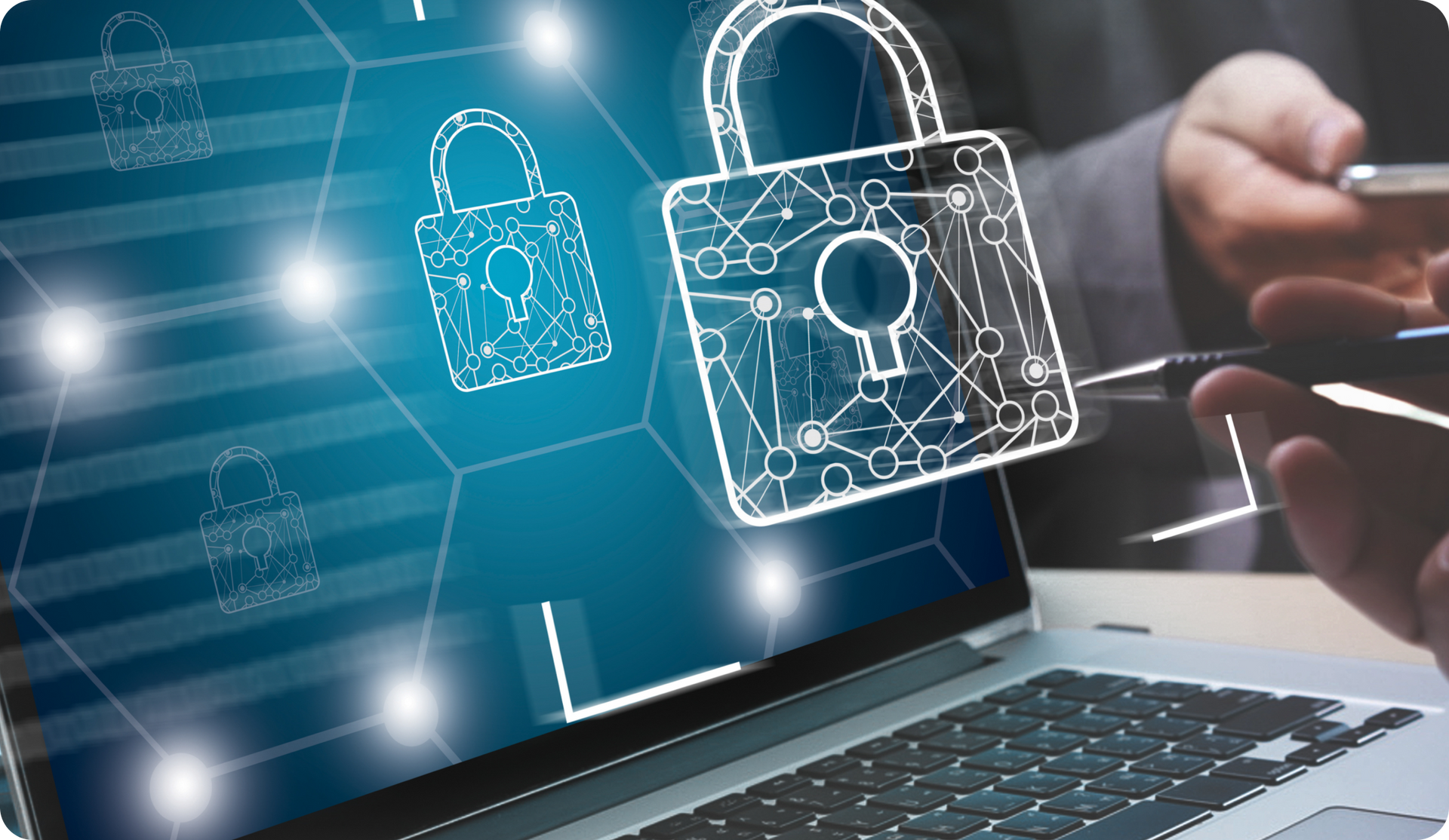 Laptop displaying a digital padlock, with a person using a phone in the background, symbolizing data security.