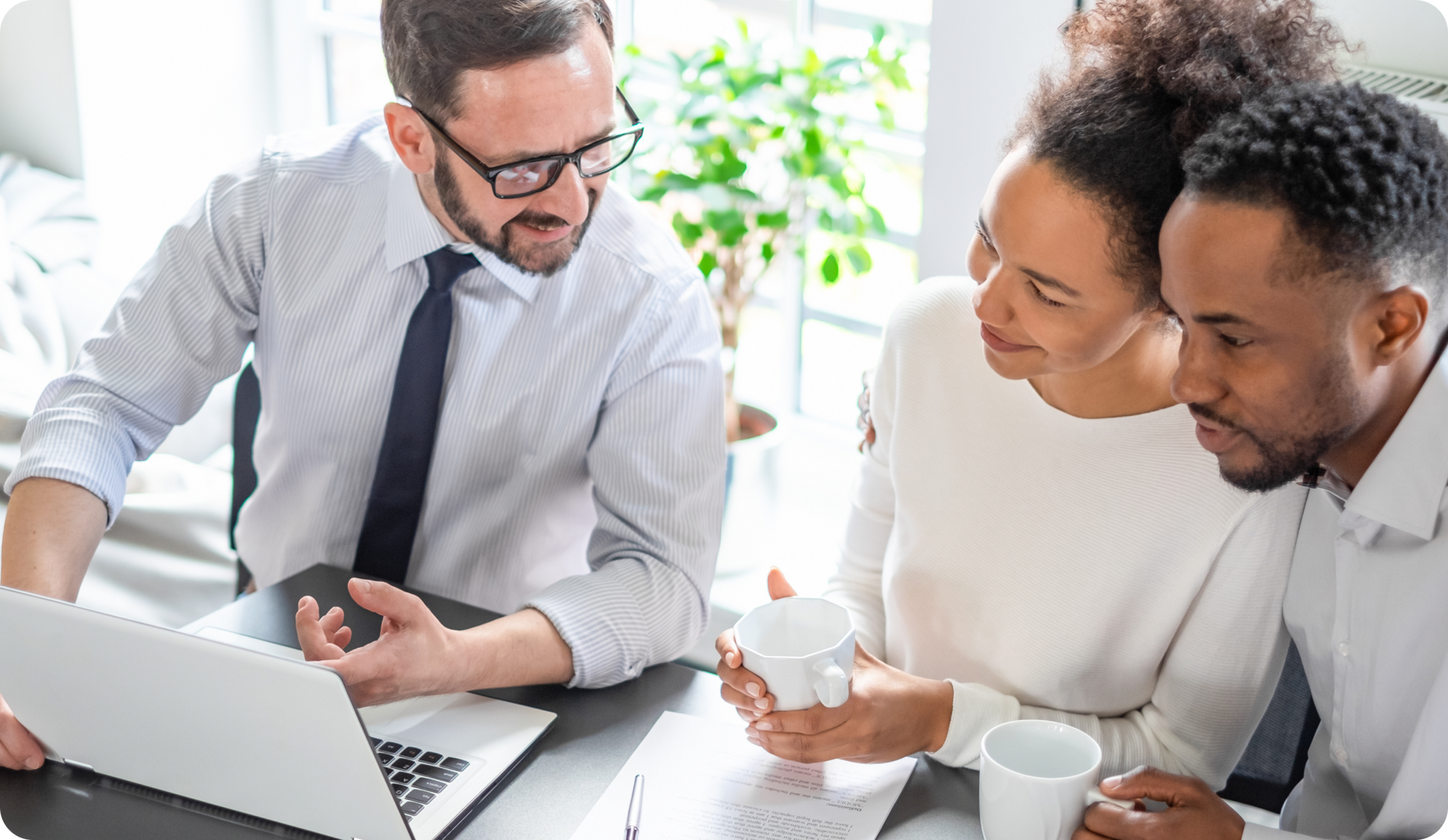 Financial advisor with a couple looking at a laptop; discussing finances.