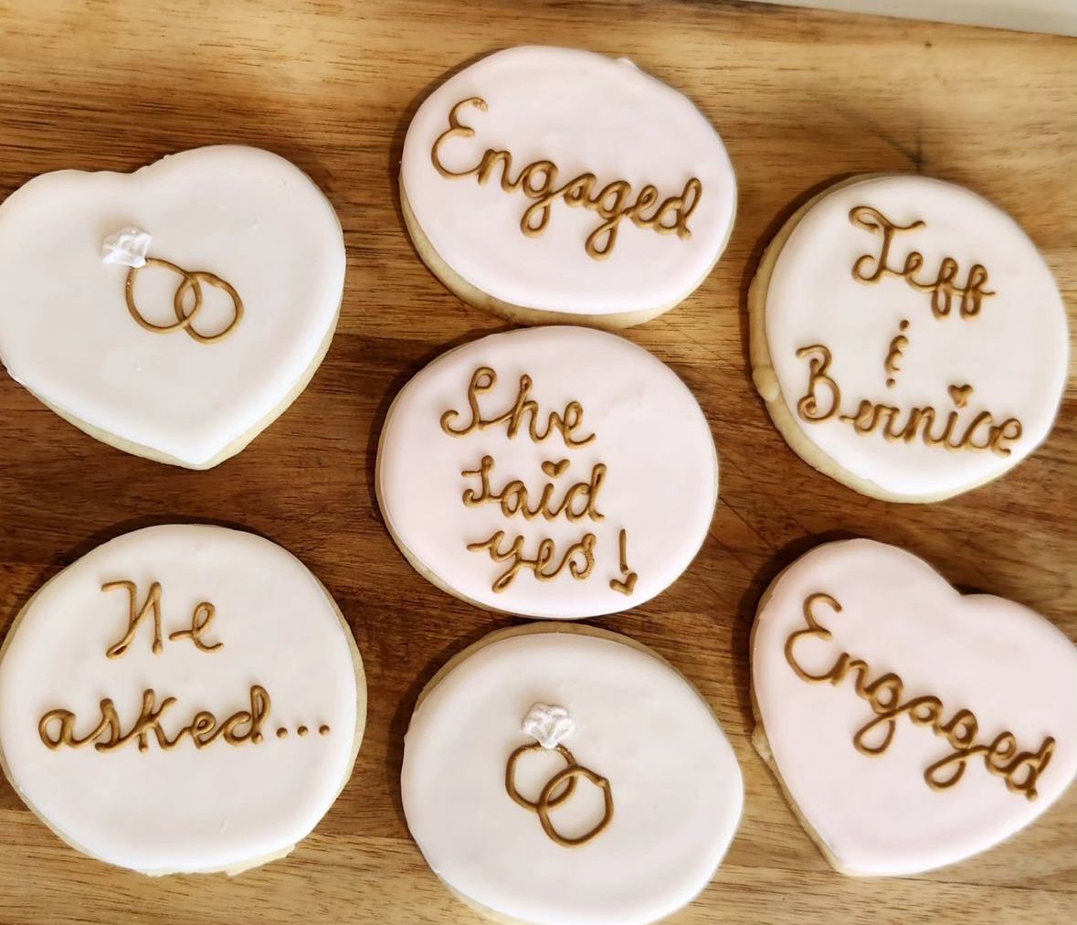 Engagement cookies decorated with icing and brown writing.
