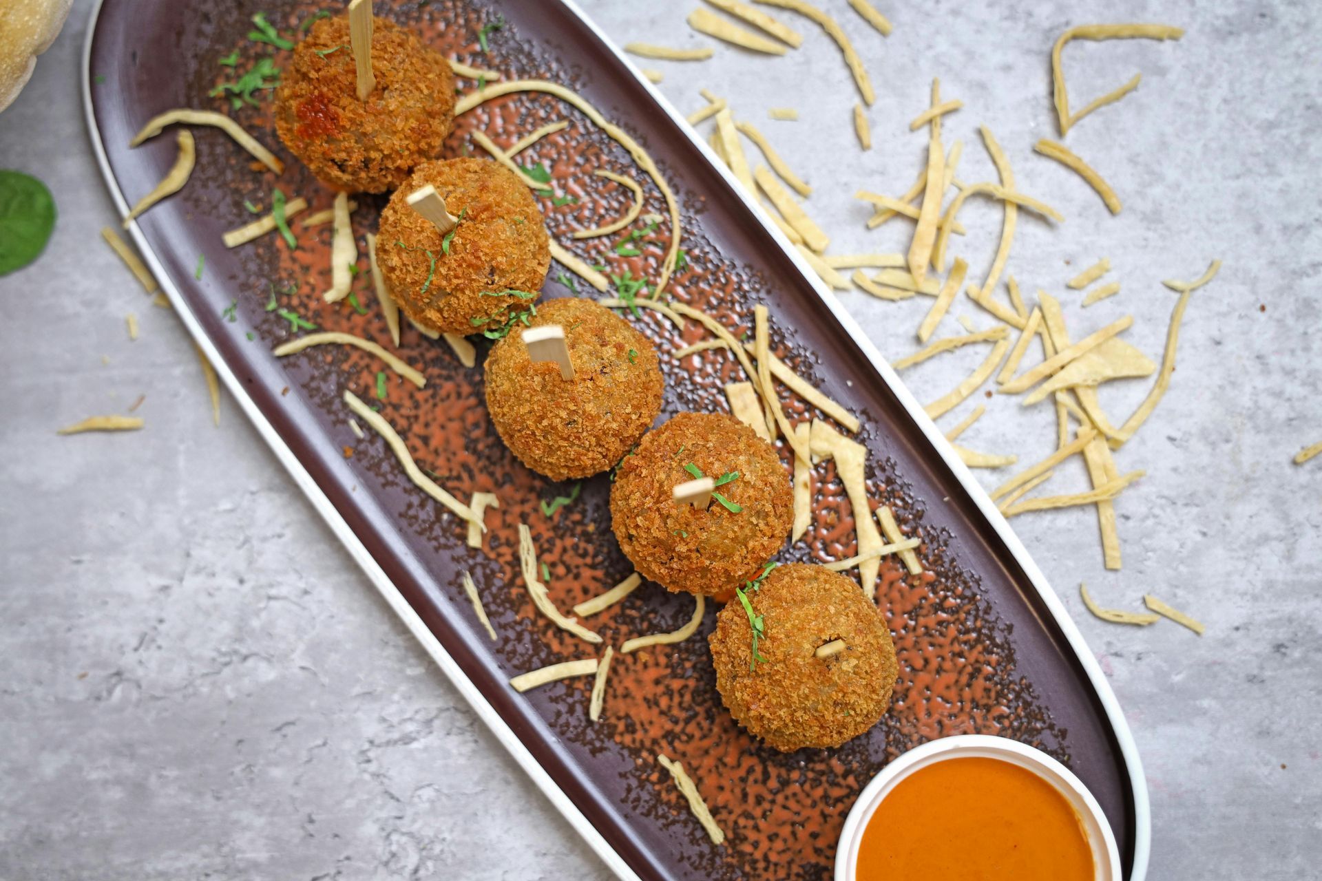 A plate of food with a bowl of dipping sauce on a table.