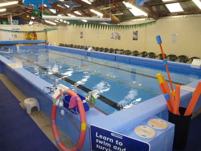 Indoor swimming pool with lane markers, filled with water, ready for swimming lessons.