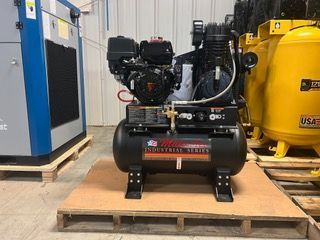 An air compressor is sitting on top of a wooden pallet.