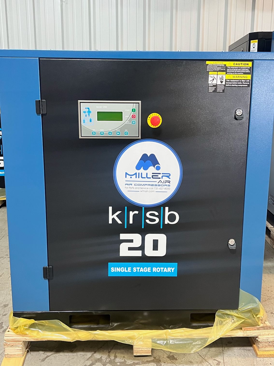 A miller krsb 20 air compressor is sitting on a wooden pallet.