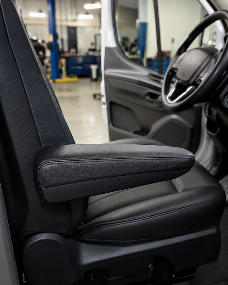 Sedile grigio per veicoli con bracciolo nero all'interno di un furgone in officina