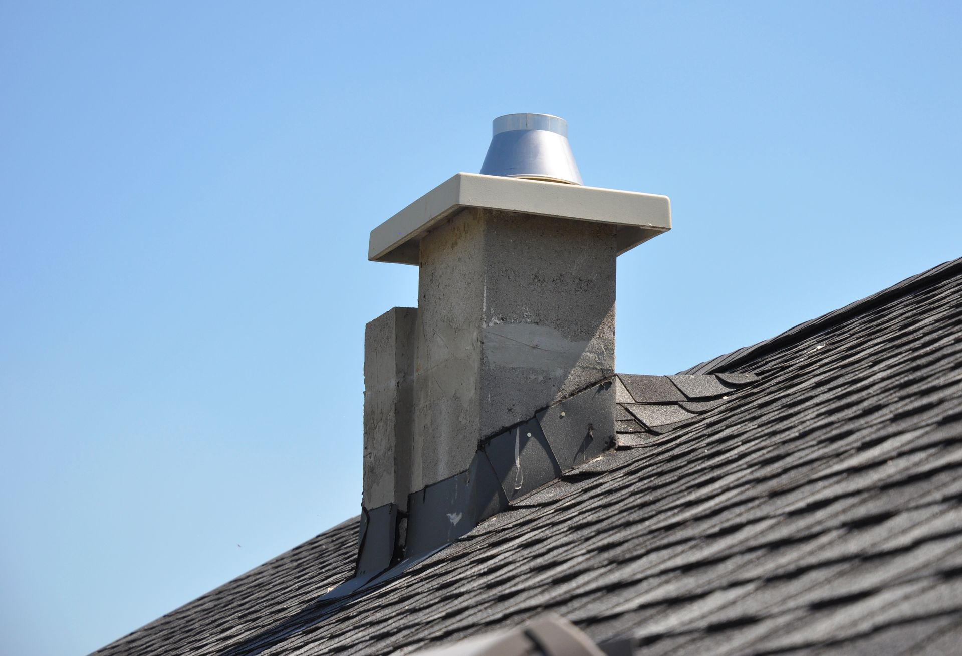 A chimney on top of a roof with a blue sky in the background