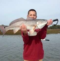 Person holding a large fish on a boat or dock over water