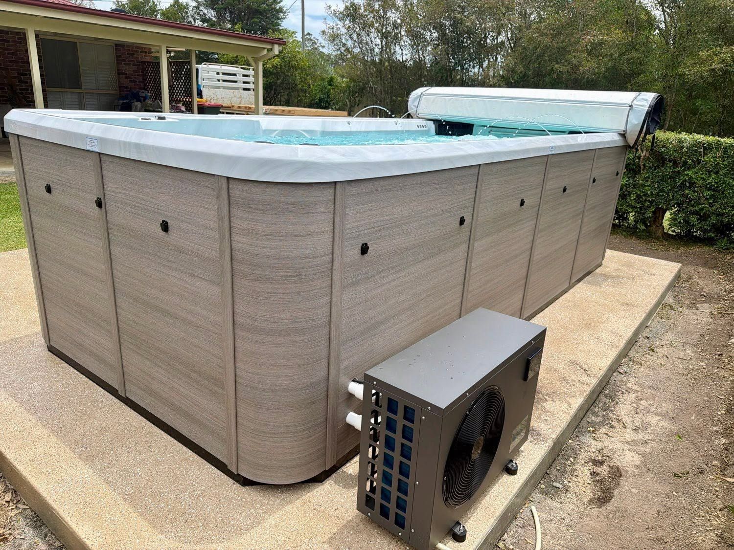 Outdoor Spa With Grey Siding, Light Blue Cover, and Nearby Heater — Cascade Pool & Spa Centre in Port Macquarie, NSW