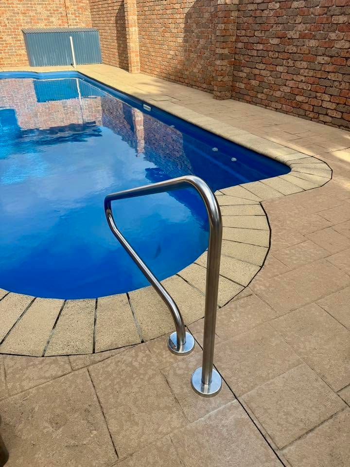 Swimming Pool With Metal Handrail, Blue Water, and Brick Wall — Cascade Pool & Spa Centre in Port Macquarie, NSW