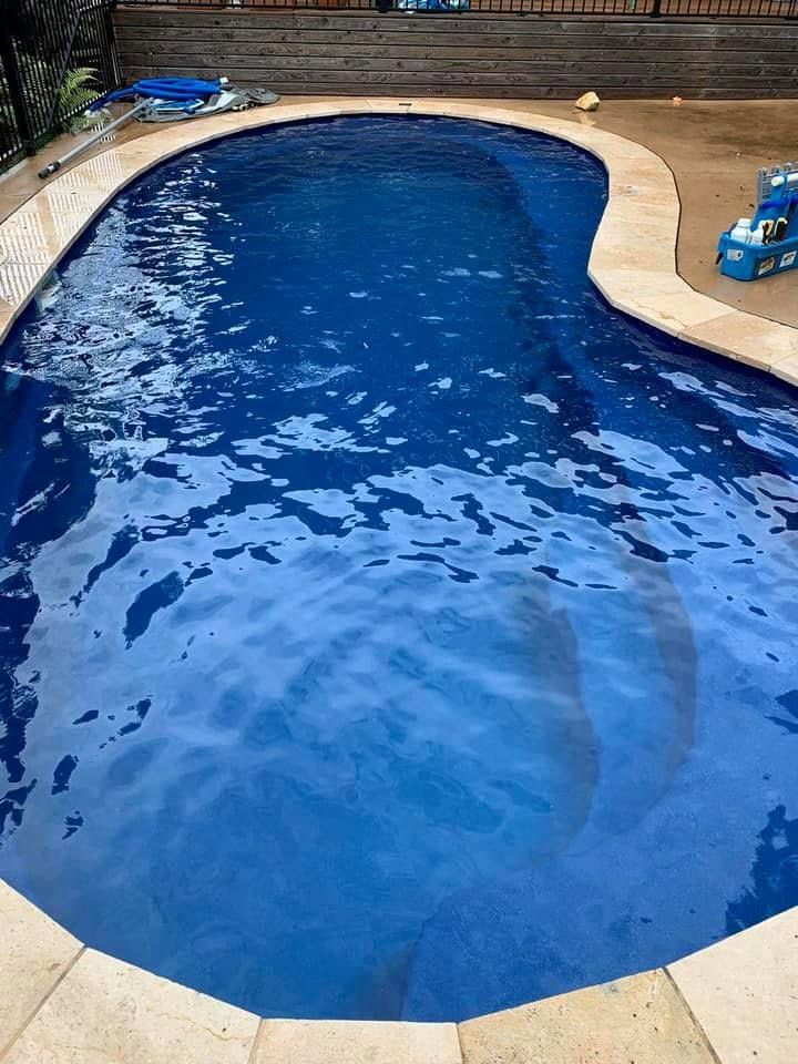 Swimming Pool With Beige Stone Deck and Clear Water Reflections — Cascade Pool & Spa Centre in Port Macquarie, NSW
