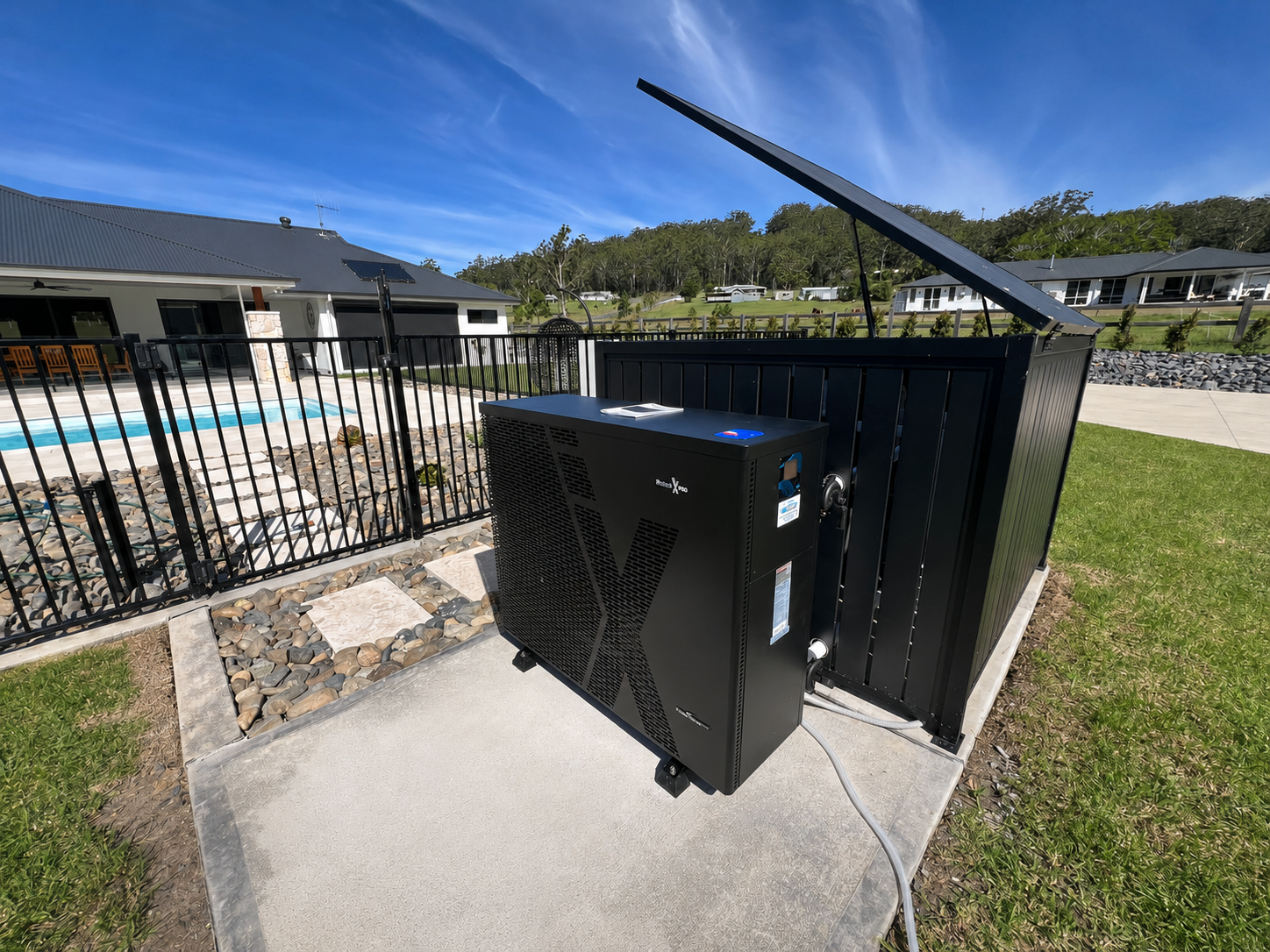 Black outdoor HVAC unit beside white PVC pipes against a weathered wooden fence. — Cascade Pool & Spa Centre in Port Macquarie, NSW