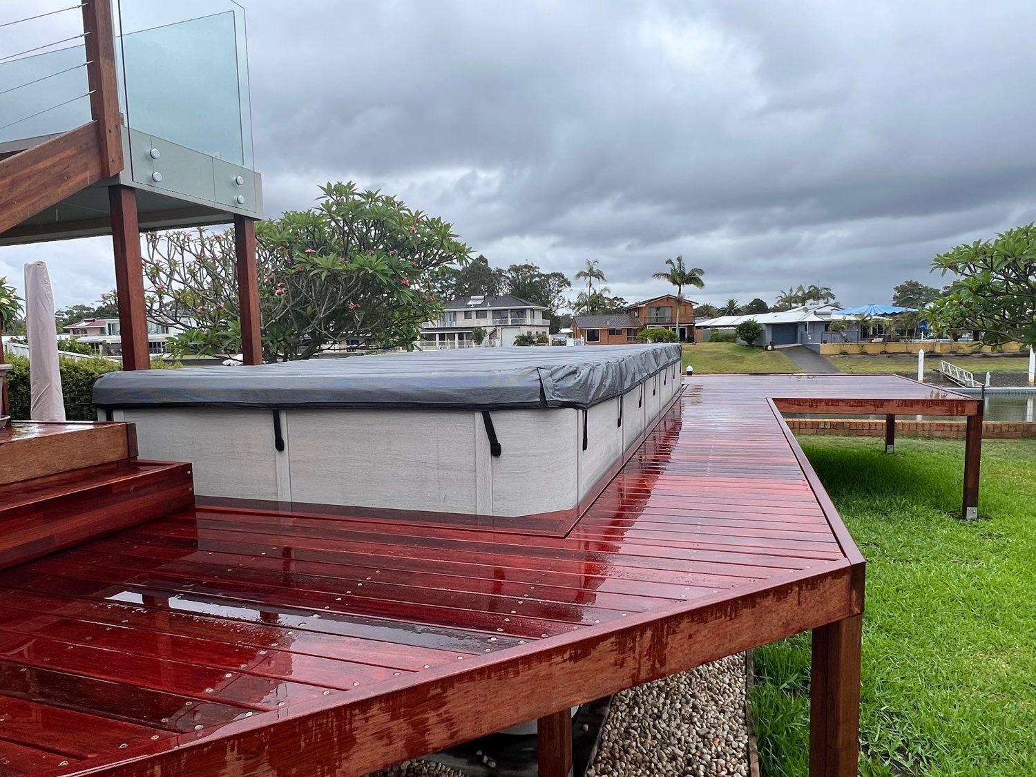 Hot tub on a wooden deck overlooking a grassy yard under cloudy skies — Cascade Pool & Spa Centre in Port Macquarie, NSW