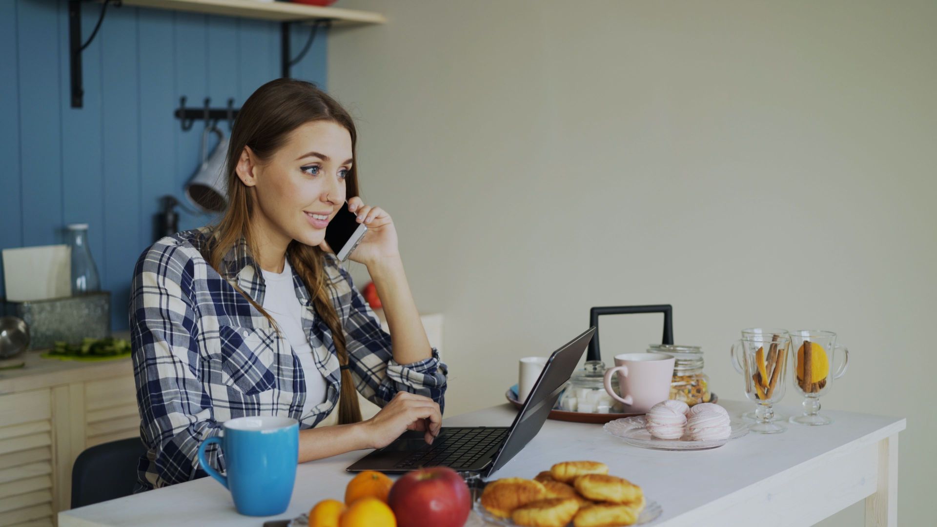 A resident making a phone call while seated at a laptop.