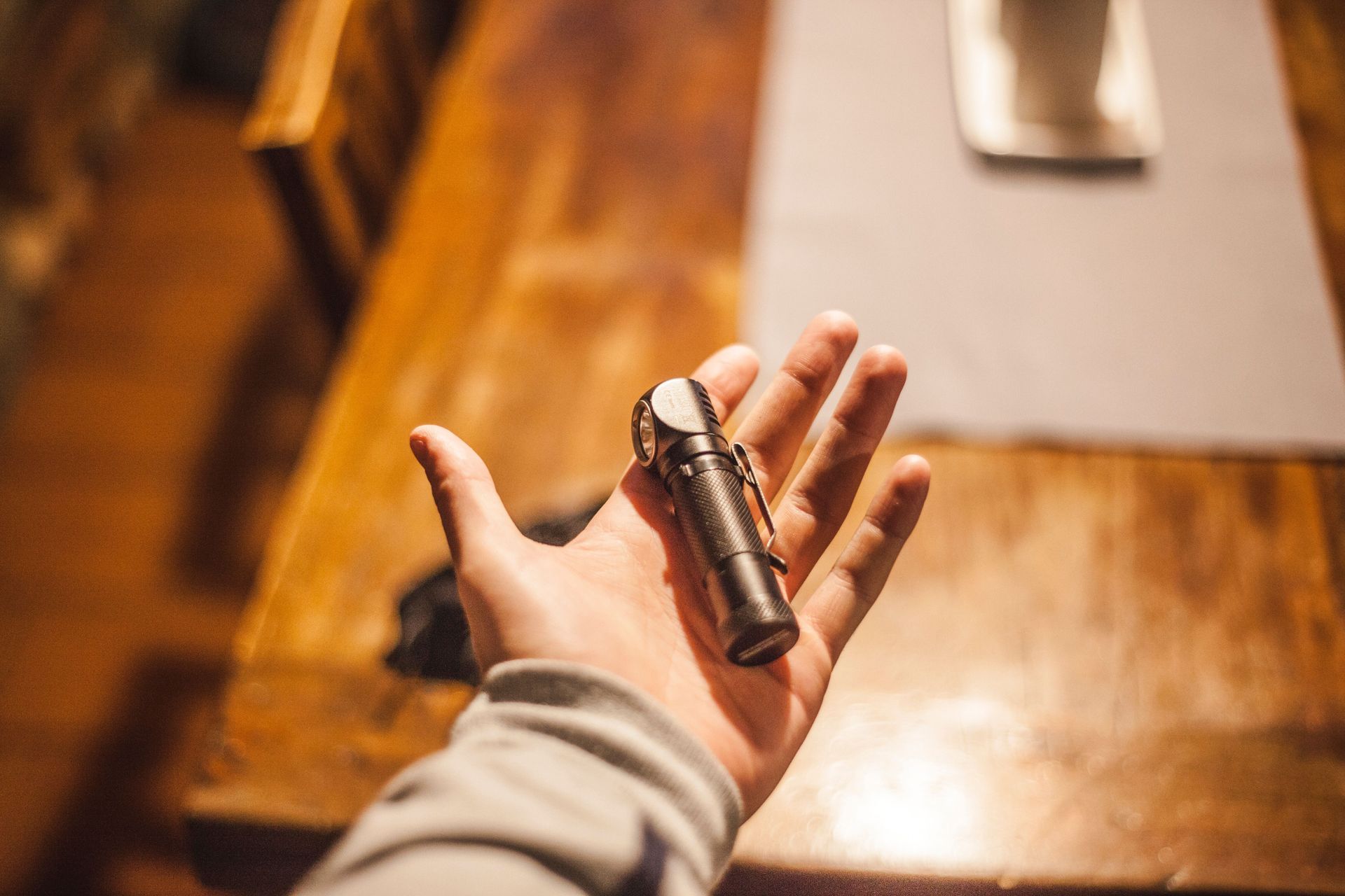 A compact flashlight held in a person's hand.