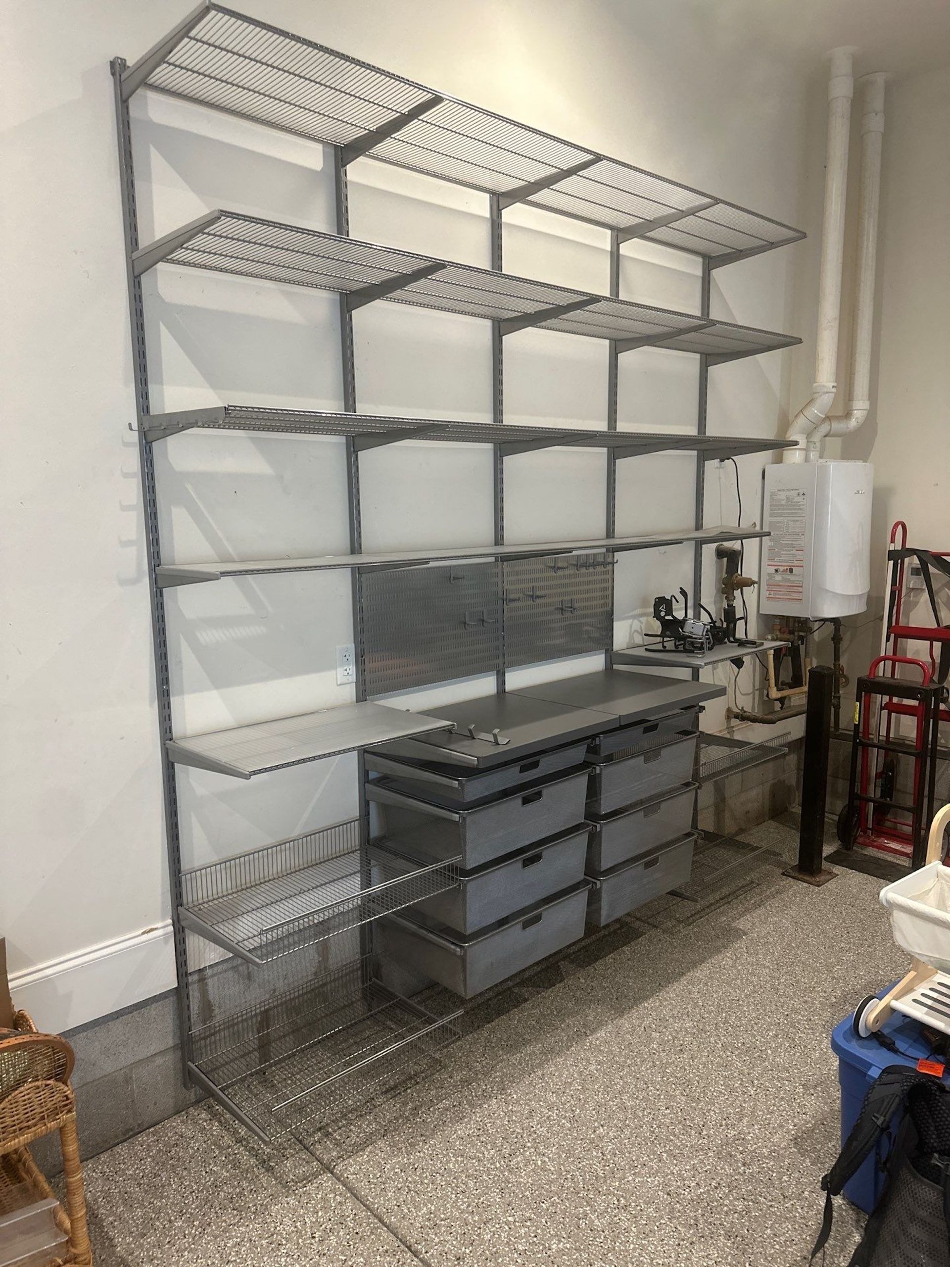 Metal shelving unit with drawers and various shelves in a garage.