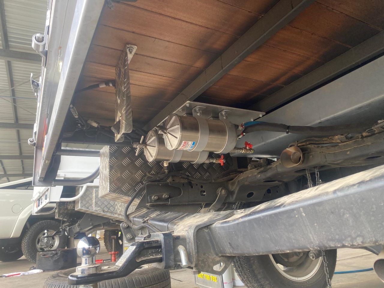 A truck with a trailer attached to it is parked in a garage.