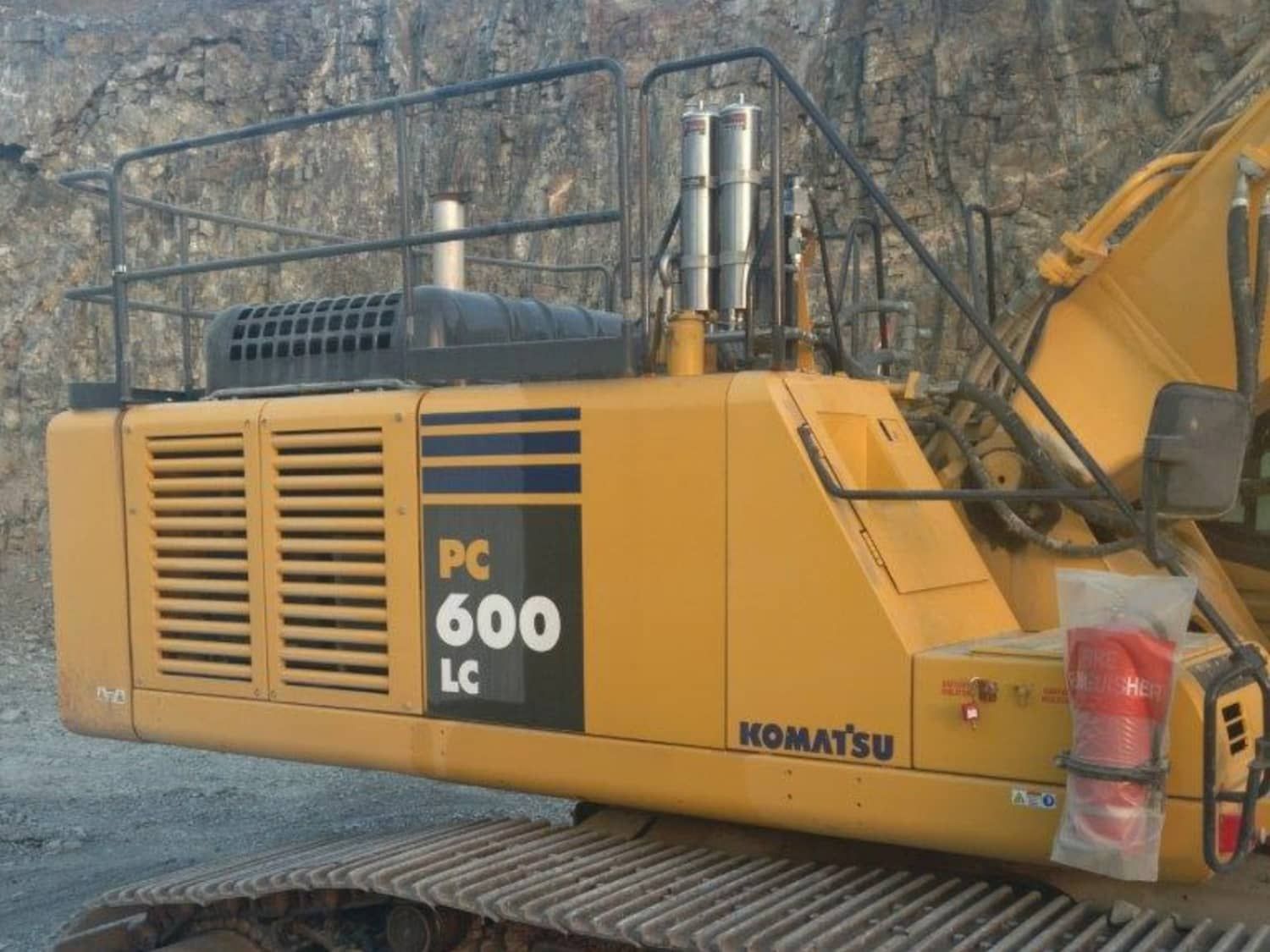 A komatsu pc 600 lc excavator is parked on the side of the road