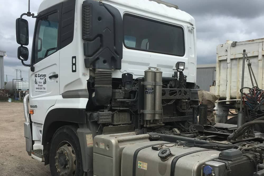 A white semi truck is parked in a parking lot.