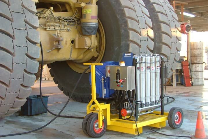 A tractor is being serviced by a yellow cart