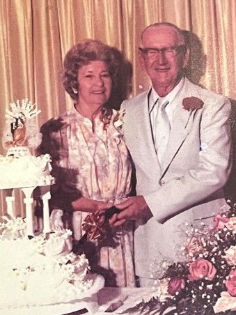 A man and a woman are cutting a wedding cake.