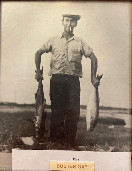 A black and white photo of a man holding two fish
