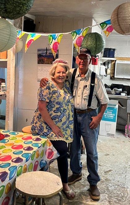 A man and a woman are standing next to each other in a kitchen.