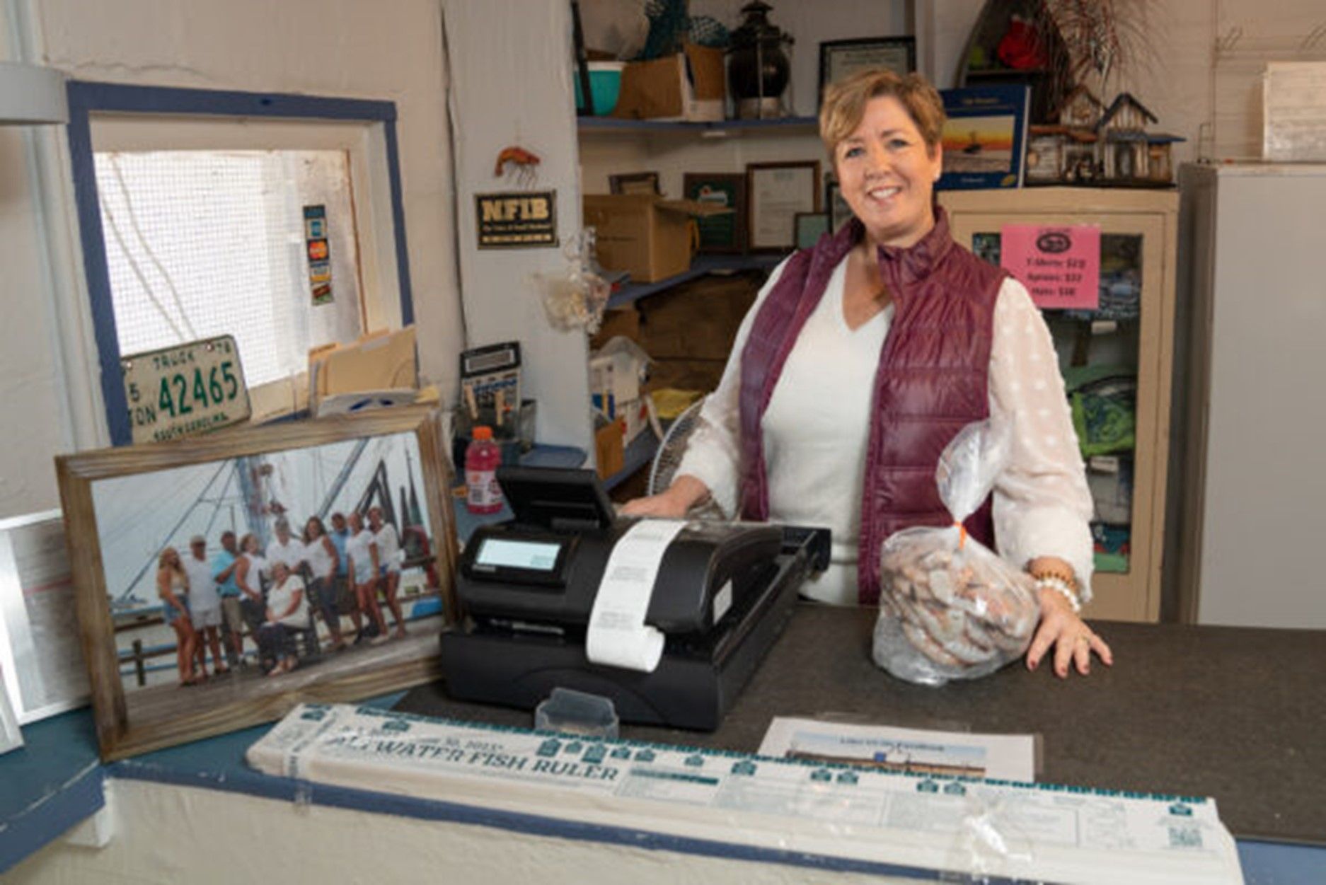 A woman is standing behind a counter in a store.