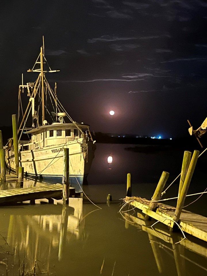A boat is docked at a dock at night
