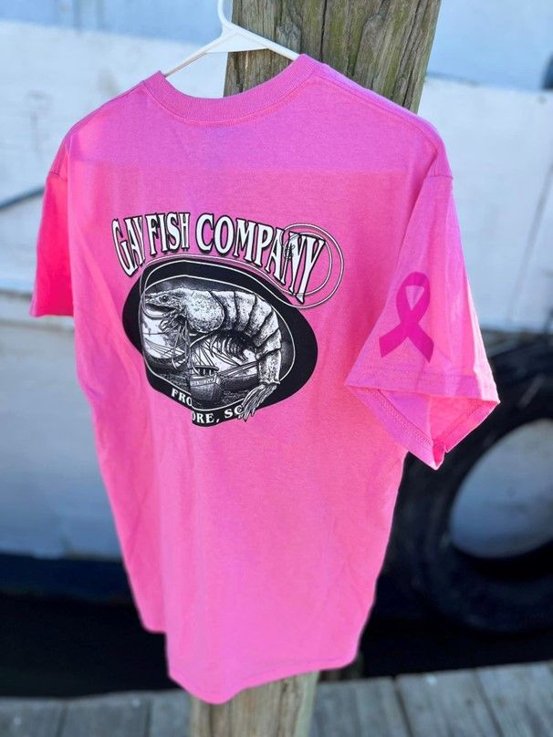 A pink t-shirt with a shrimp on it is hanging on a hanger.