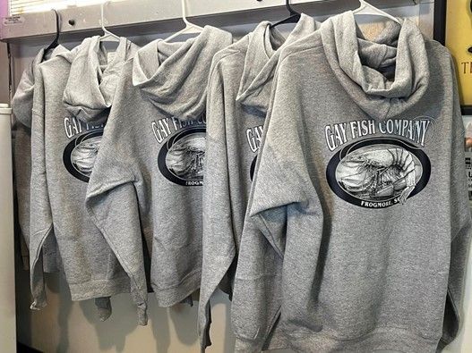 A row of gray hoodies hanging on a rack.