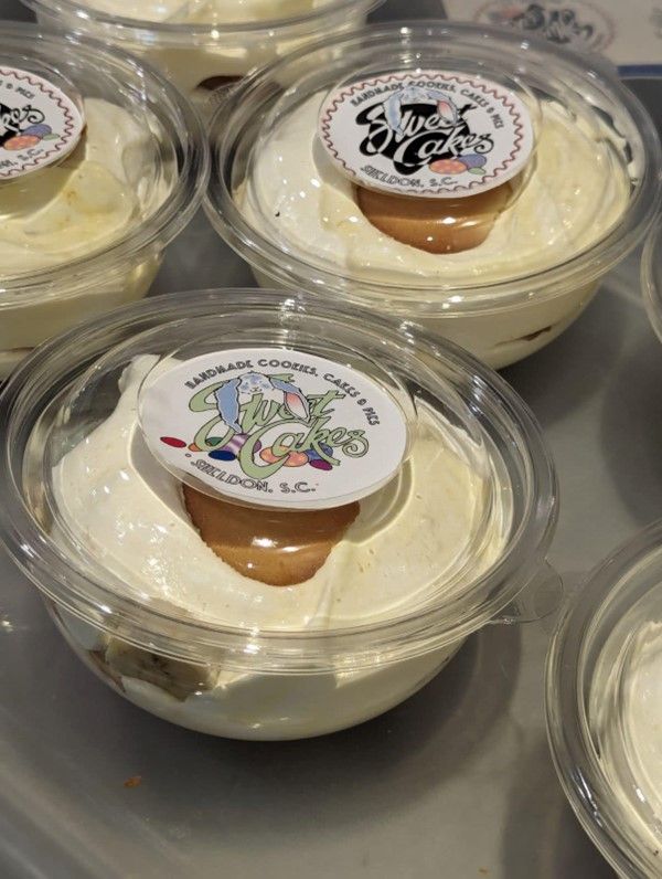 A close up of a dessert in a plastic cup on a table.