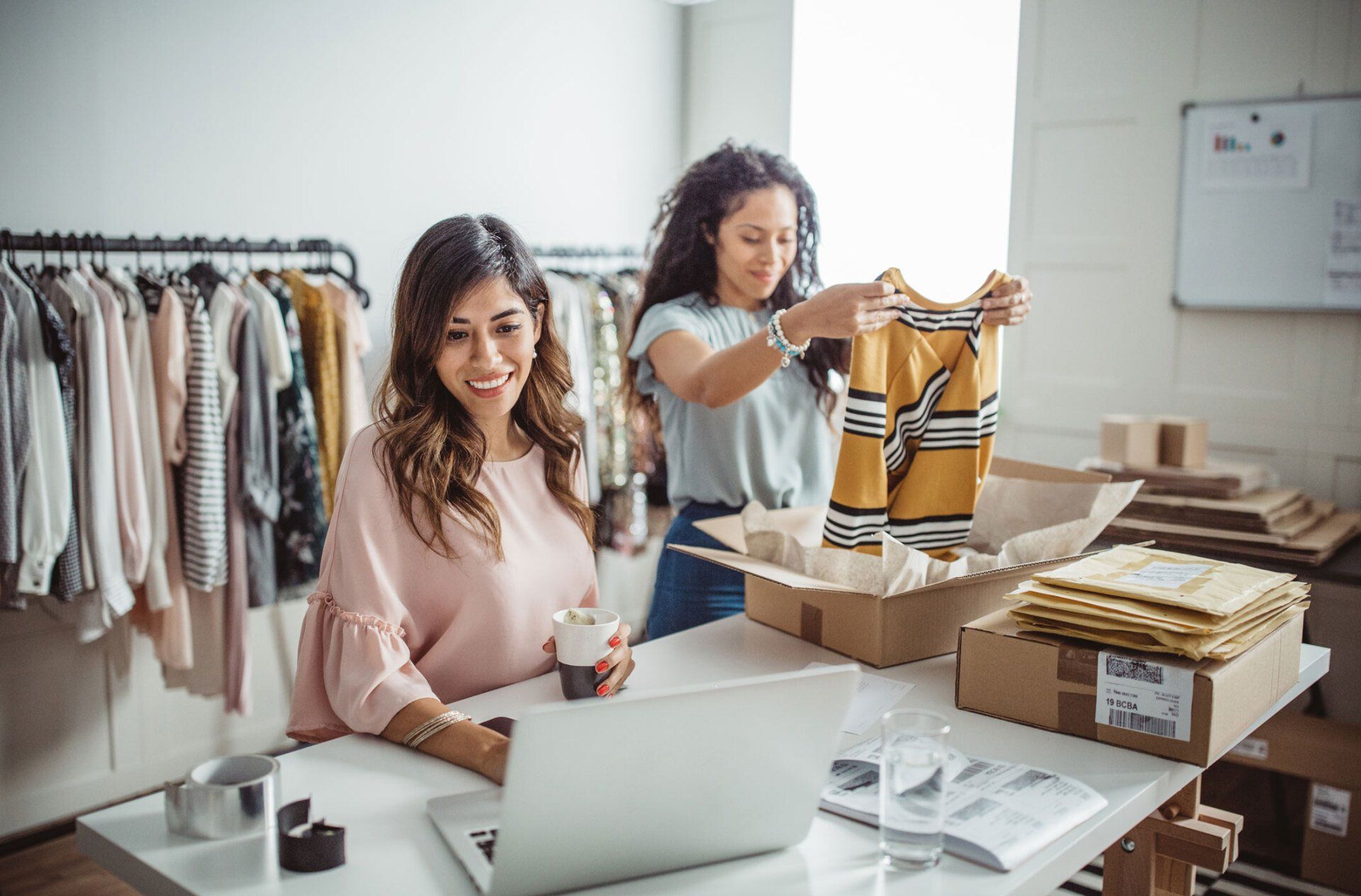 Two women sorting and packing women clothes that demonstrate customer service excellence.