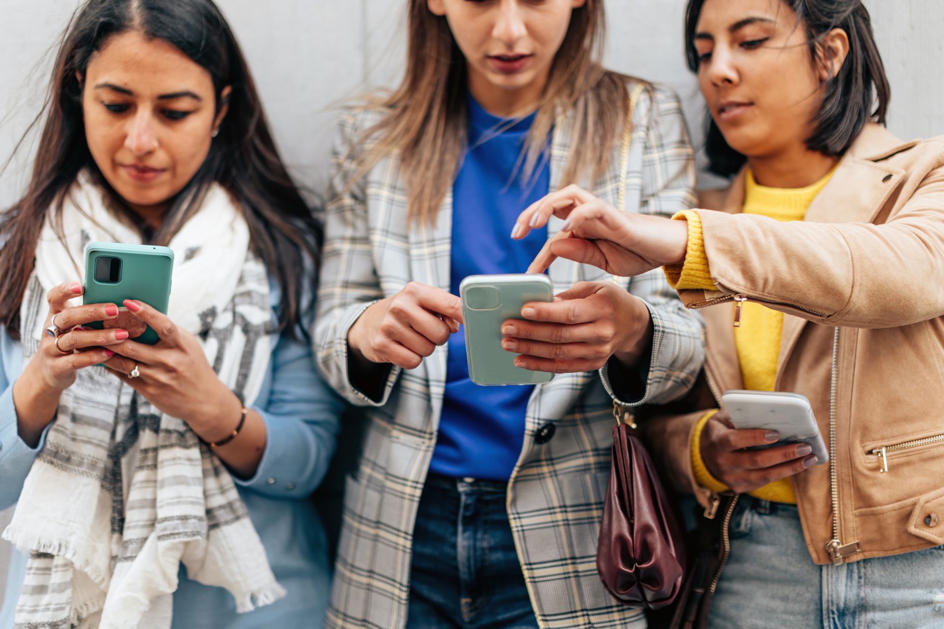 Three women using their phones to stay connected.