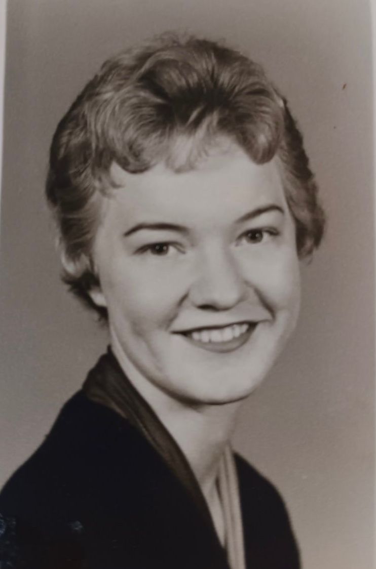 A black and white photo of a woman smiling for the camera.