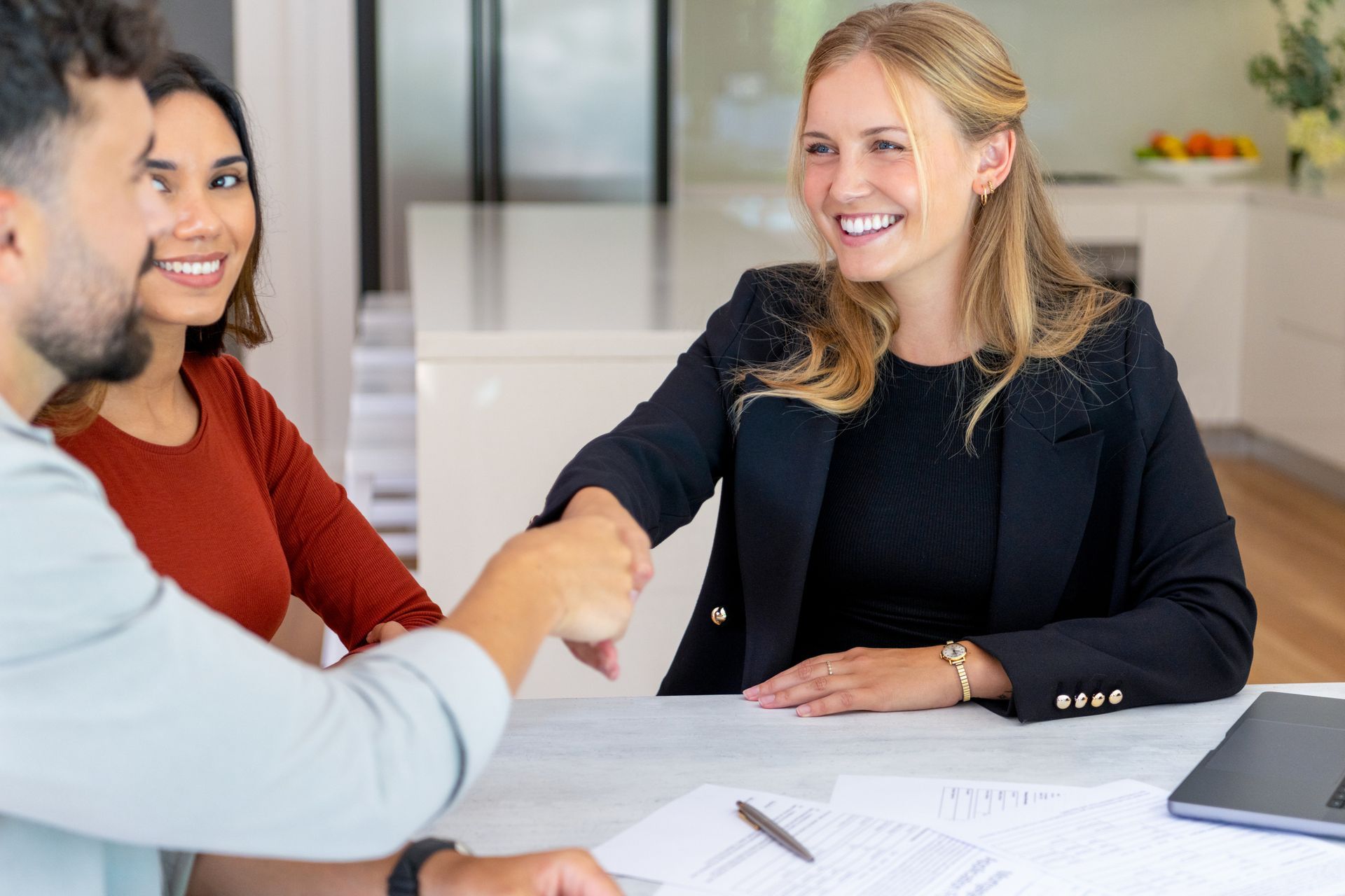Two colleagues shake hands during a meeting on auto insurance agency solutions.