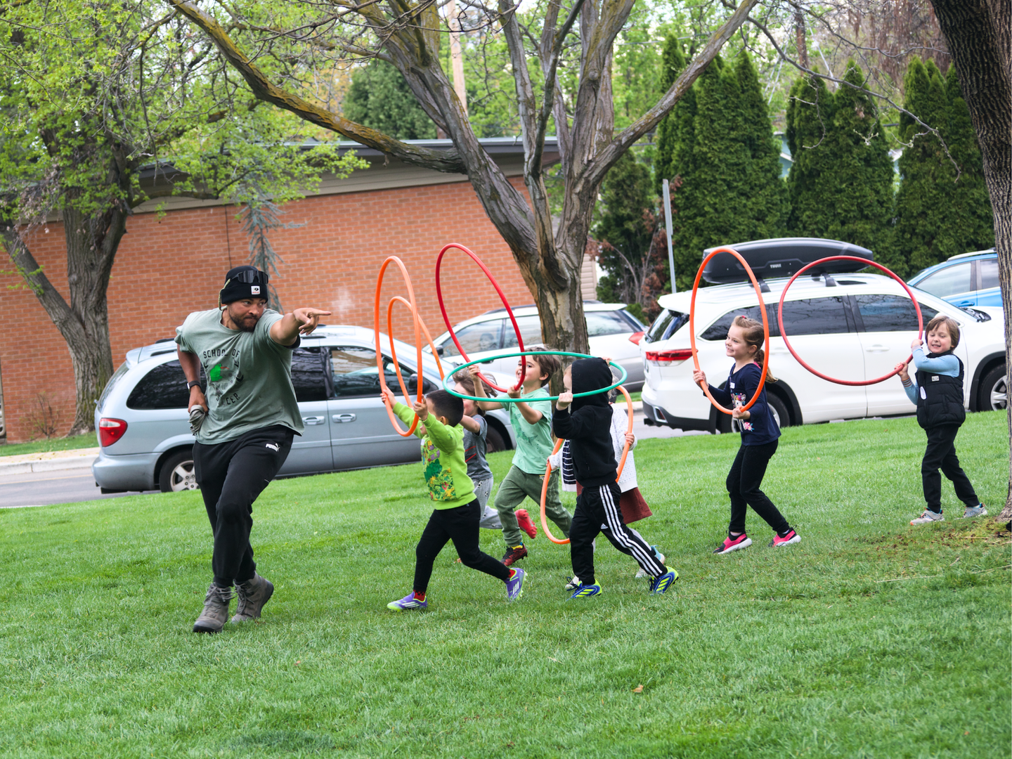 Soccer coach running with young players during practice.