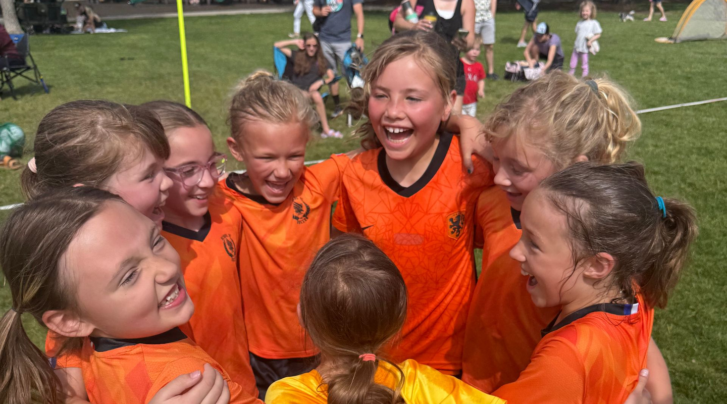 School of Soccer players celebrating after a match.
